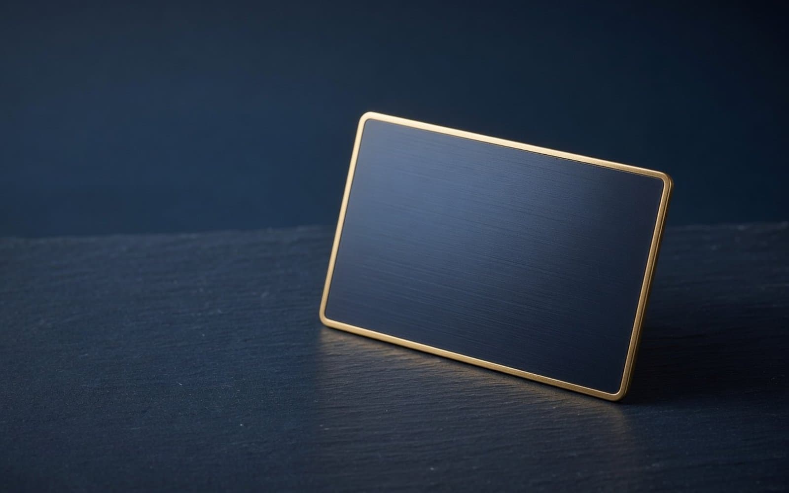 A blank navy metal card with gold edges